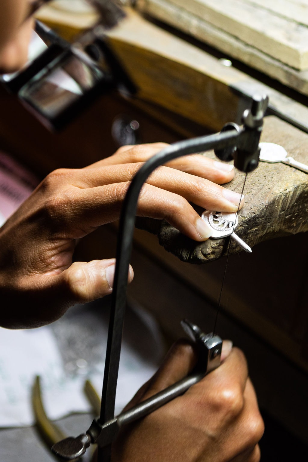 A Golden Casting jeweler sawing a piece at the bench